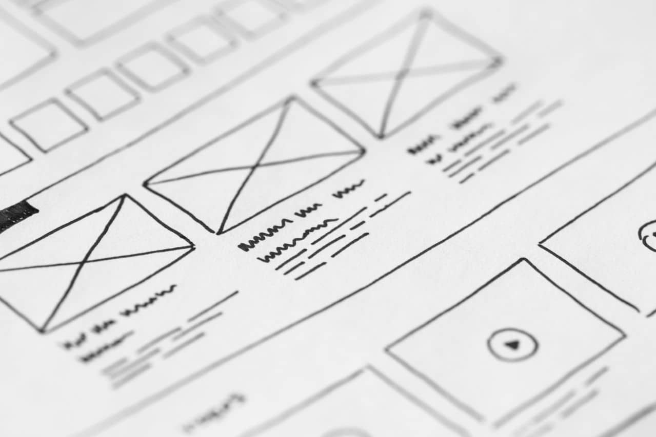Website wireframe sketch being drawn by hand